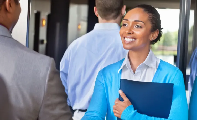 Professional young woman greeting someone at a networking event