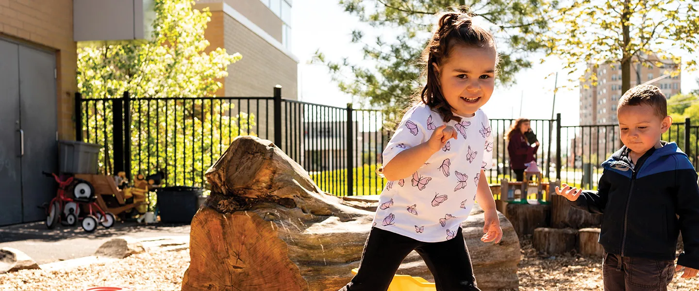 Two children joyfully playing together in a playground area.