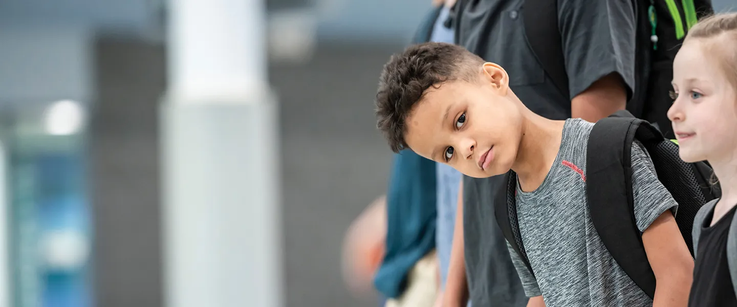 A diverse group of children lined up, all looking forward with cheerful expressions