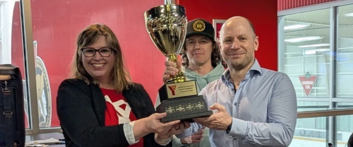 Three people holding the championship trophy