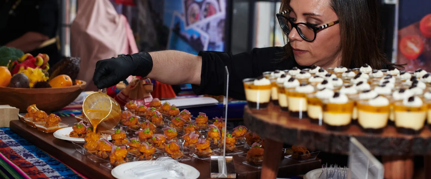 A woman preparing food displays at a cultural booth