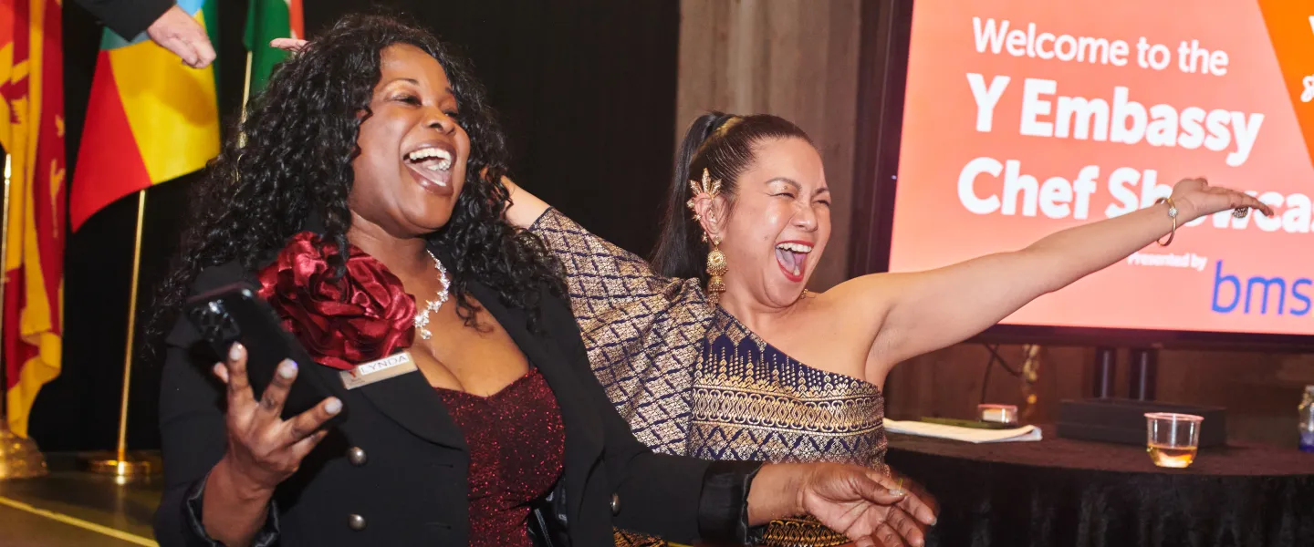 Two women smiling and outstretching their arms