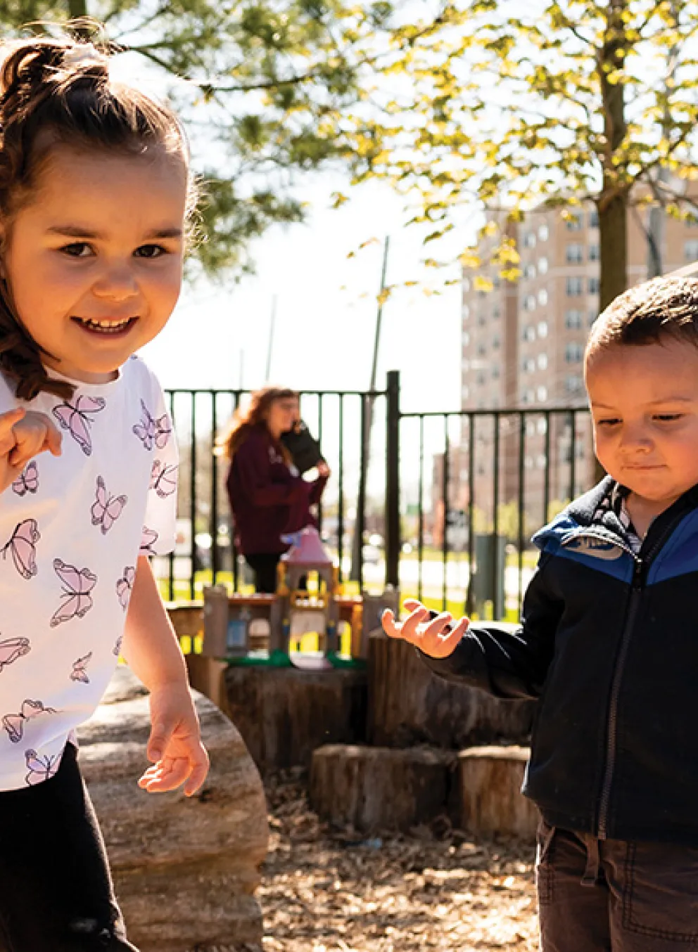Two children joyfully playing together in a playground area.