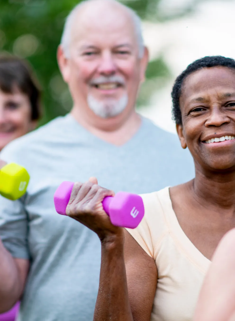 Seniors lifting hand weights in an outdoor setting
