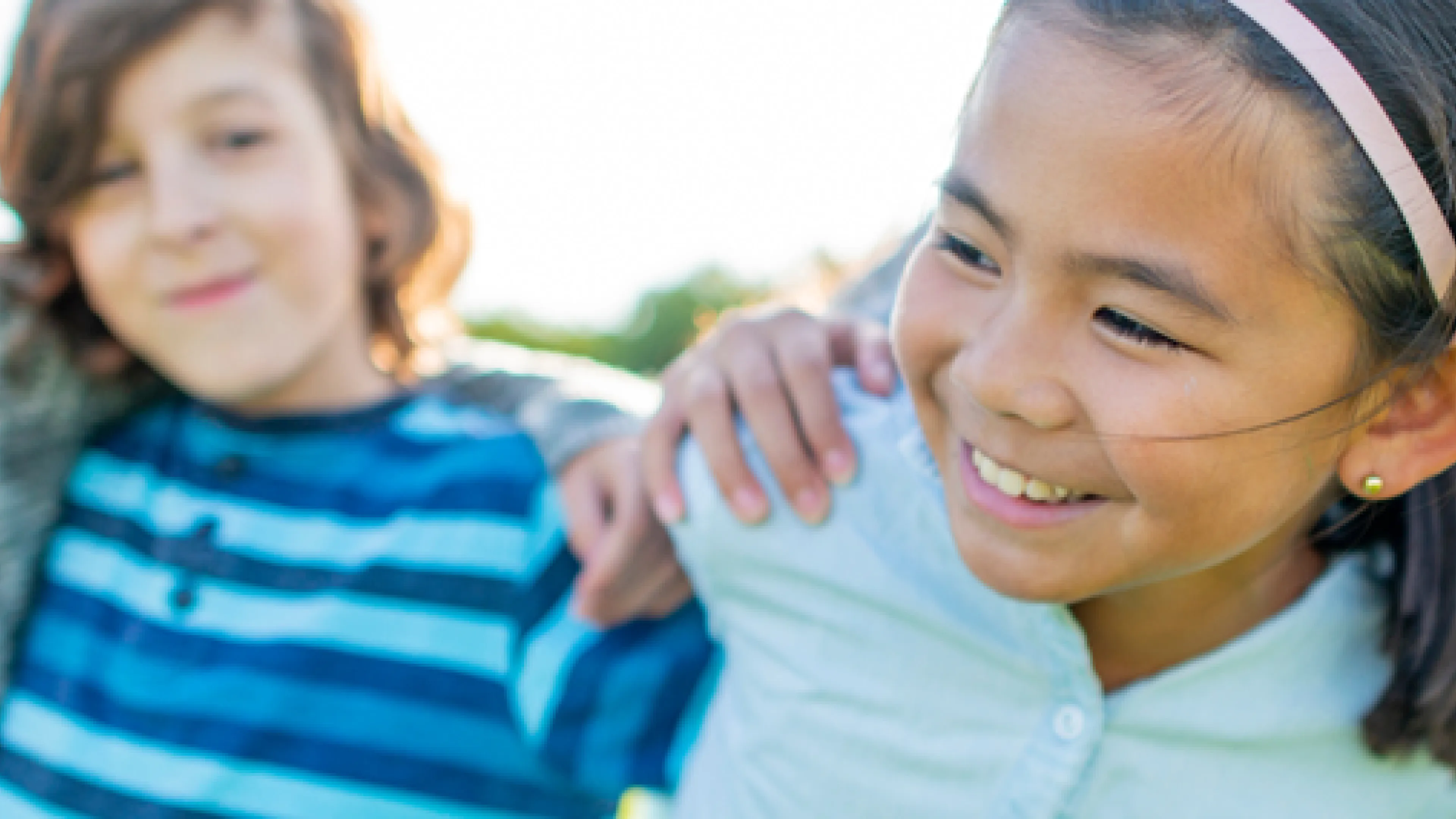 Four children with their arms around each other's shoulders