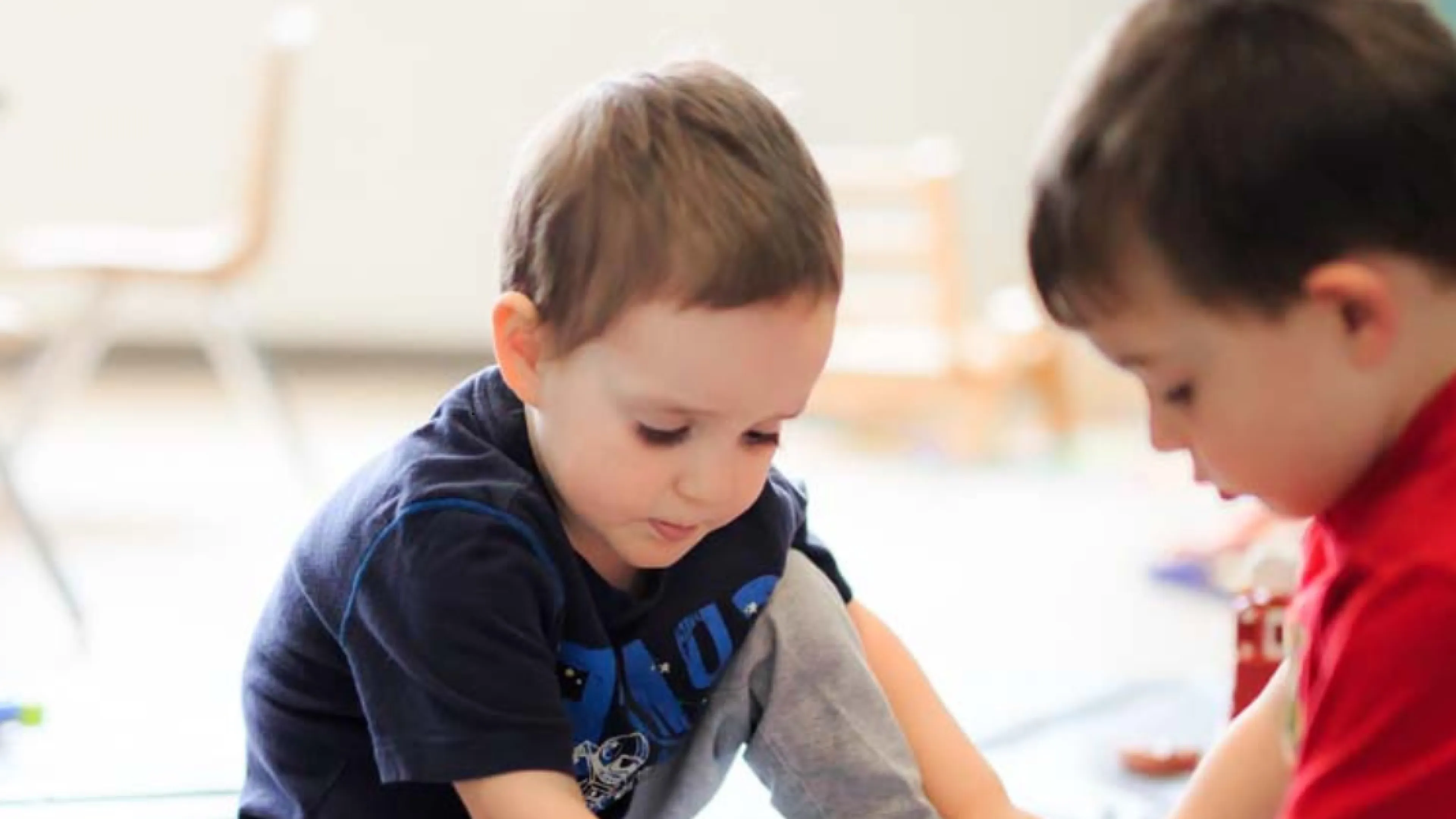 Two children play on the floor.