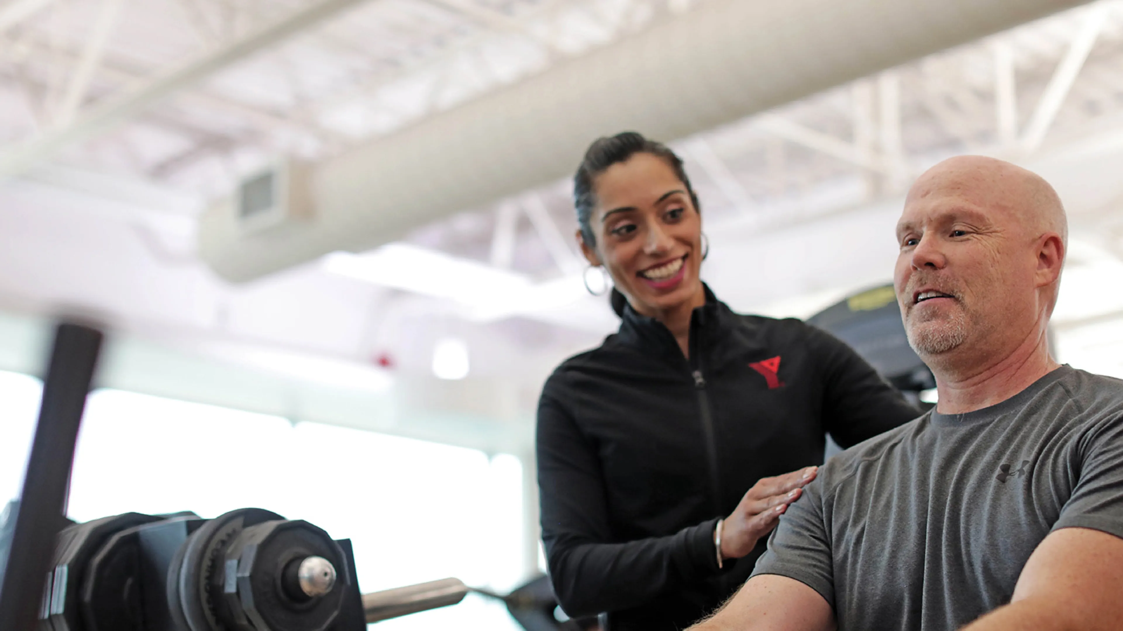 A YMCA personal trainer working with their client.