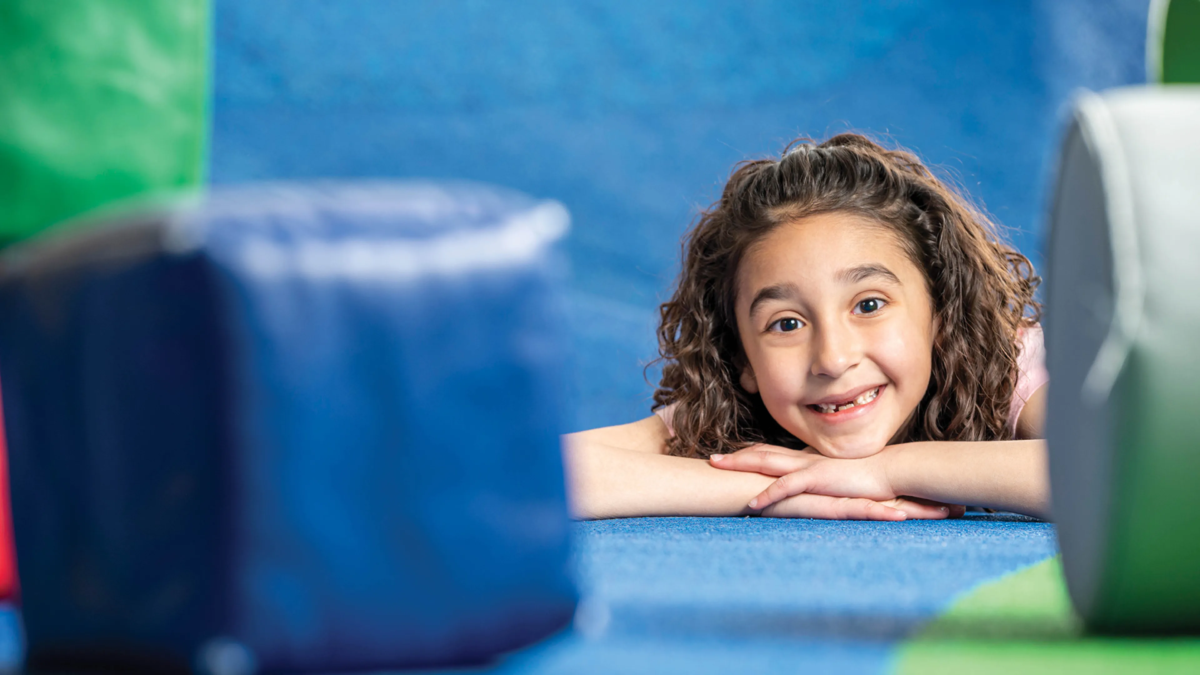 A young girl poses in a soft play area.