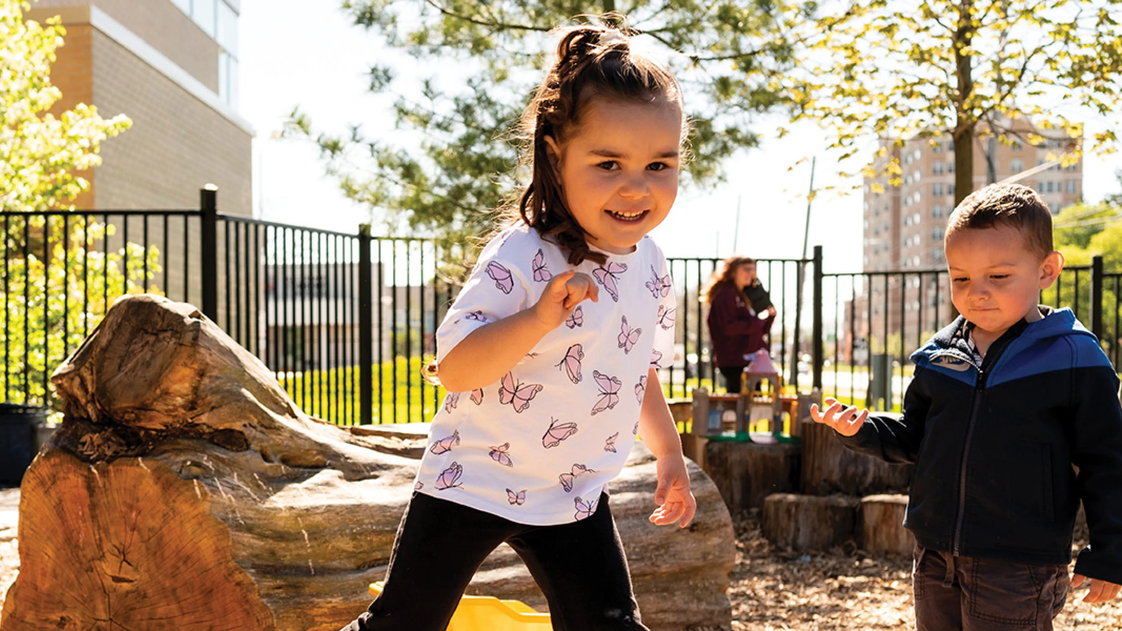 Two children joyfully playing together in a playground area.