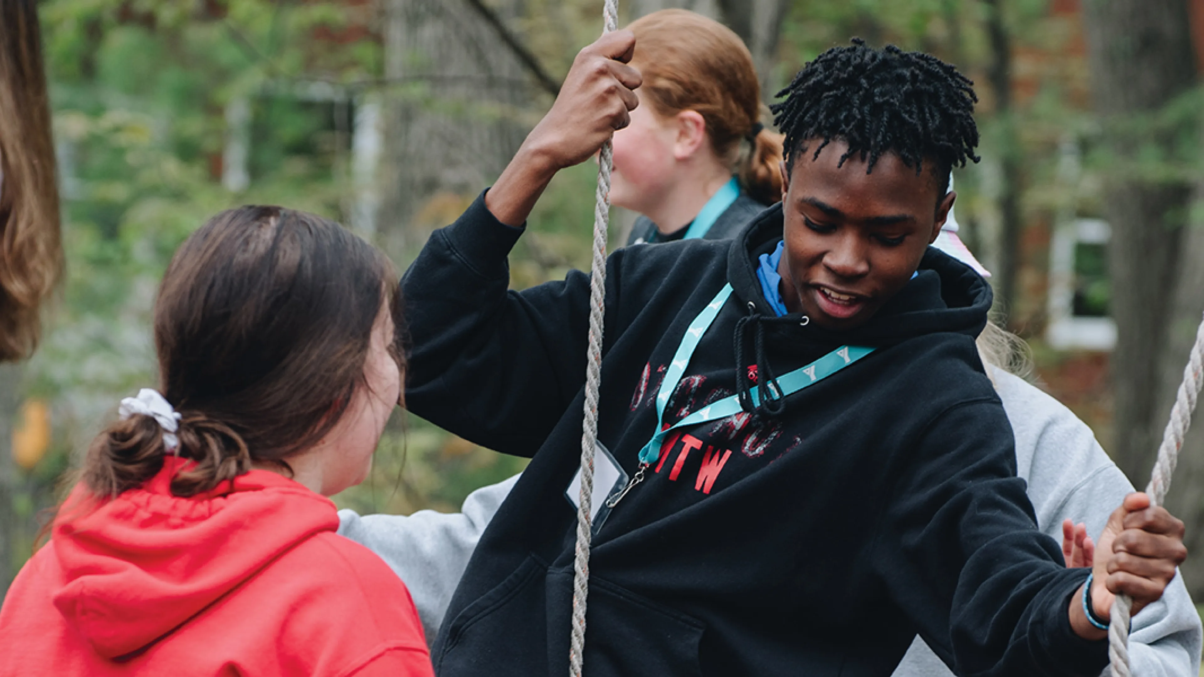 A team of people enthusiastically participating in a rope game, showcasing teamwork and fun in an open area.