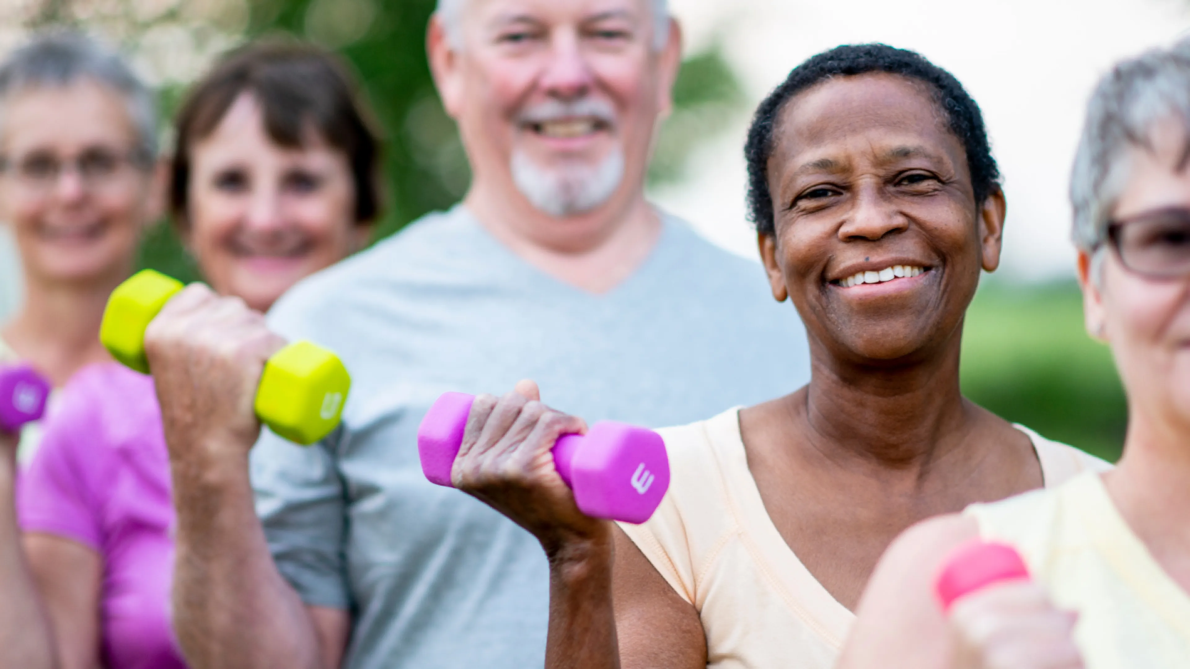 Seniors lifting hand weights in an outdoor setting