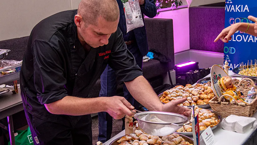 A chef sifting powdered sugar over pastries