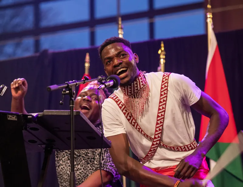 Two members of the Kamengo Cultural Troupe singing on stage at the Y Embassy Chef Showcase