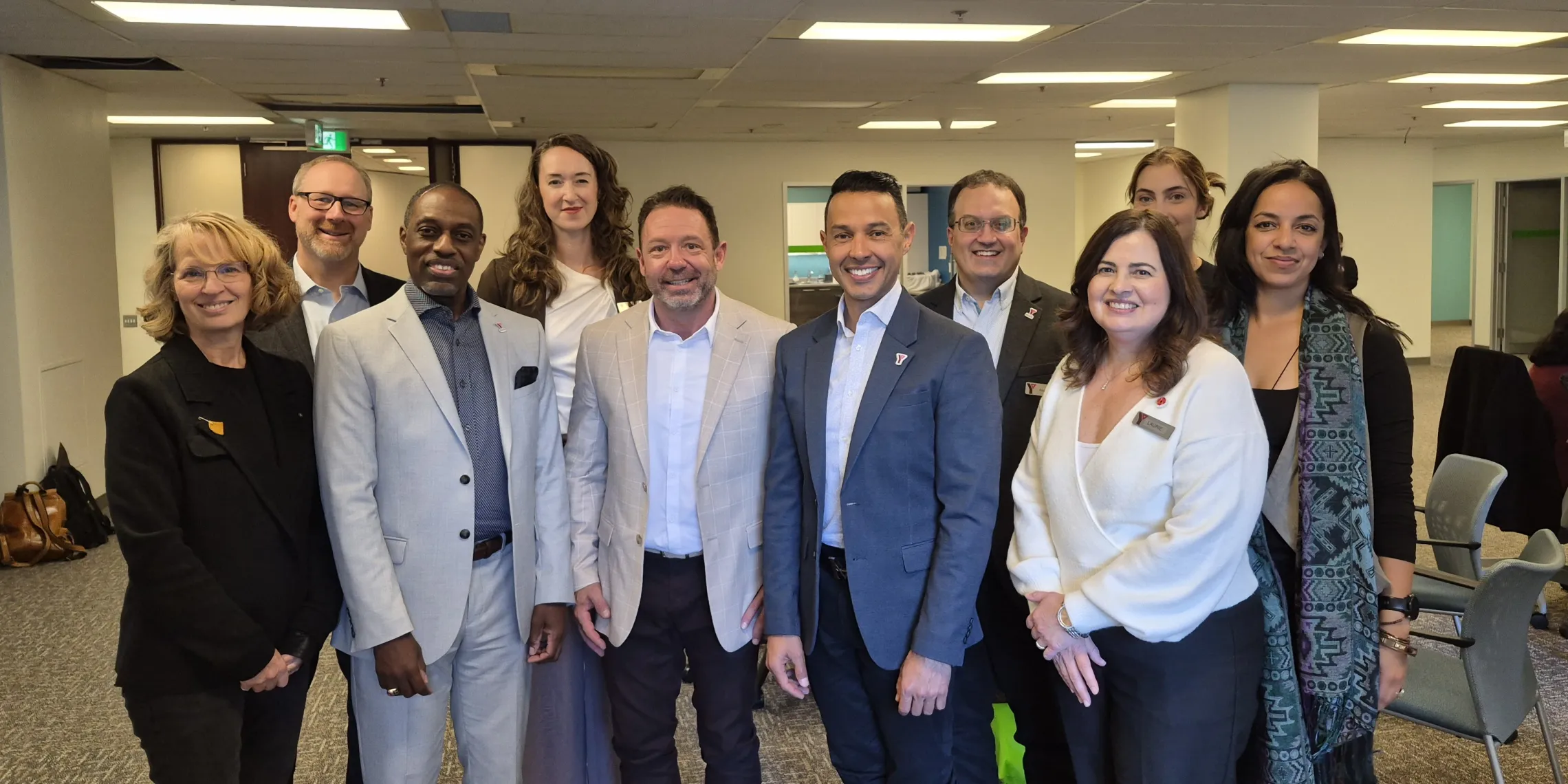 A group photo of ten people in an office, including YMCA staff members and Opening Minds representatives