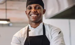 A chef smiling with his arms crossed