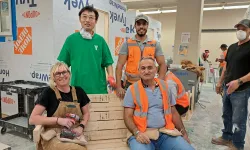 Four people wearing PPE in a construction workshop