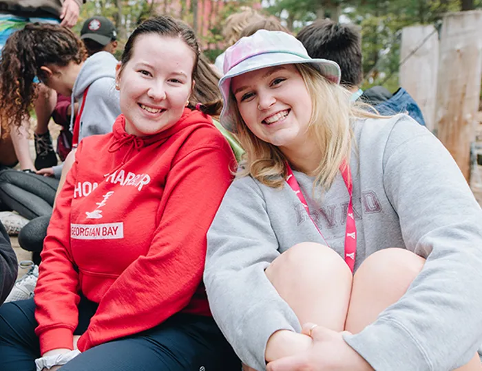 Two smiling camp councilors having fun.