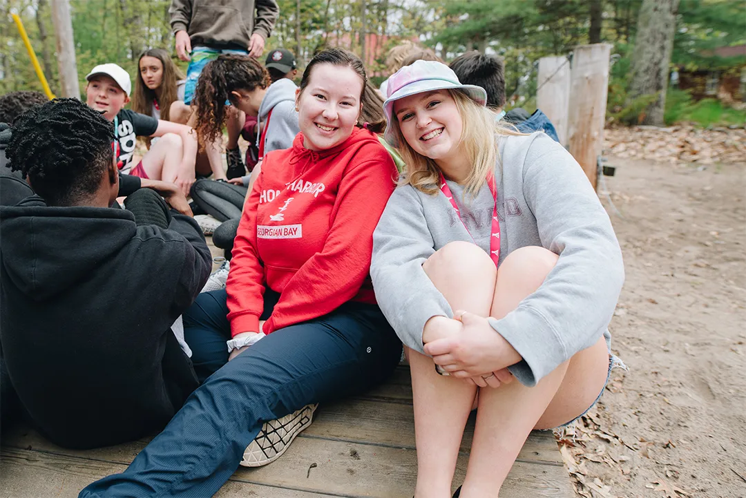Two smiling camp councilors having fun.