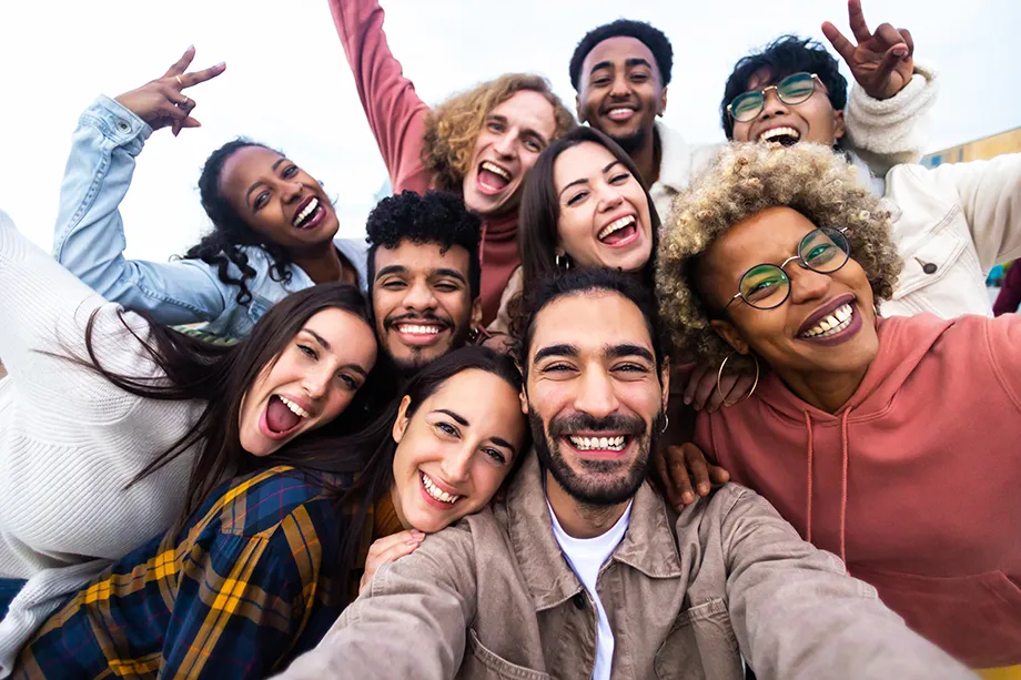A diverse group of friends smiling as they take a selfie, celebrating their shared experience.
