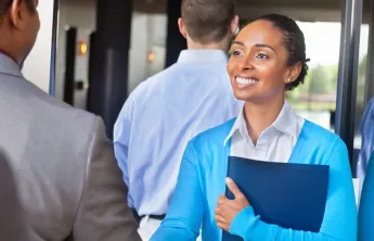 Professional young woman greeting someone at a networking event